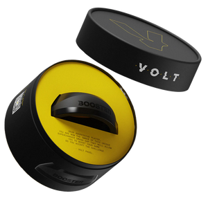The cylindrical black container labeled BOOSTER and VOLT, with a lightning bolt design on the lid, reveals a circular device inside. Its yellow interior hints at a power boost, making it perfect for padel racket accessory enthusiasts. Product: VOLT BOOSTER by Volt.